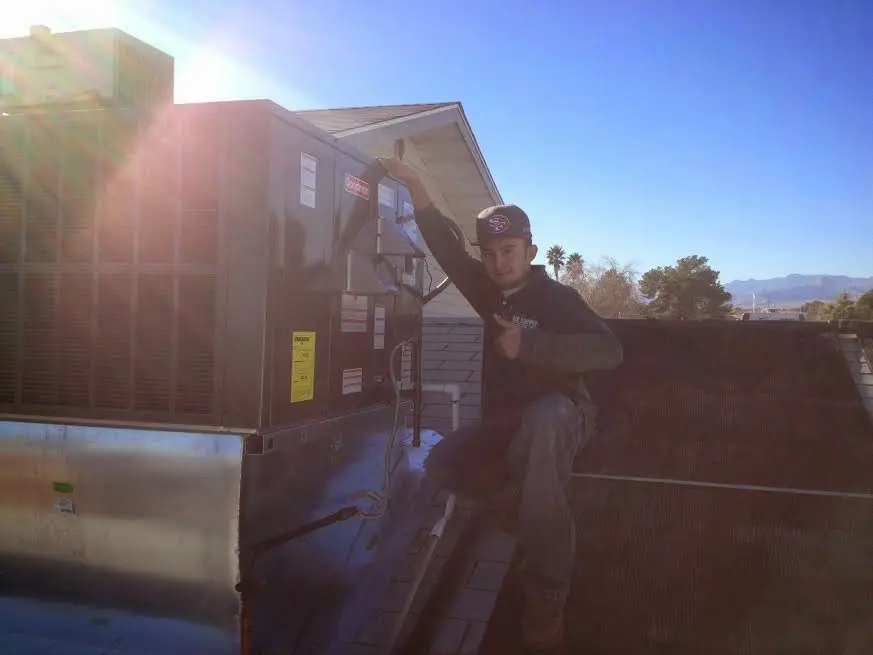 HVAC technician performing AC Tune-Up on a rooftop unit in Corbin